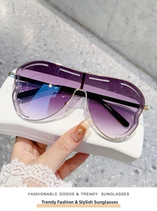 Détail de lunettes de soleil évidées avec verres dégradés violets et monture dorée