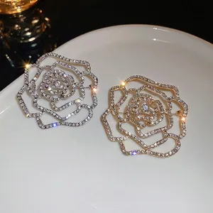 Elegant cutout rose brooches in silver and gold with sparkling cubic zirconia pavé