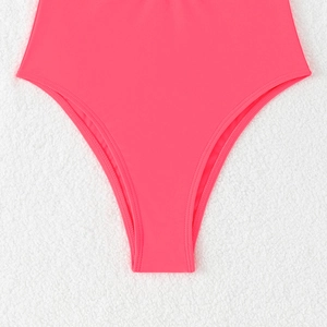 Gros plan sur un maillot de bain rose fluo échancré avec coutures détaillées