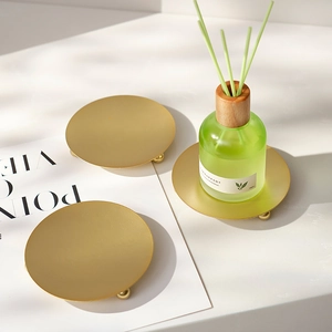 Minimalist round gold metal candle holder tray with spherical feet for home decor