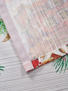 Vista macro del mantel navideño con costuras detalladas en los bordes y textura de tela