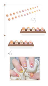 Detail of short square press-on nails with hand-painted rainbow and floral candy patterns