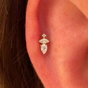 Close-up of gold cartilage stud with vertical marquise and pear-cut crystal gemstones