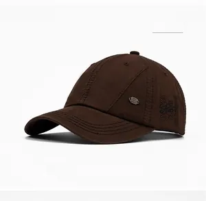 Detail view of coffee cotton baseball cap showing metal logo plate and letter H embroidery