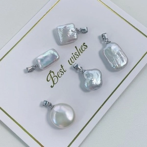 Macro shot of irregular baroque clover pearls with silver clips on a white card