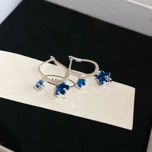 Macro shot of S925 sterling silver earrings with blue zircon star charms on display