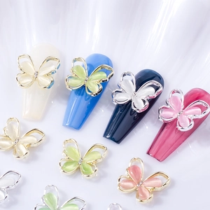 Macro shot of 3D alloy cat-eye butterfly nail charms with rhinestones on colorful tips