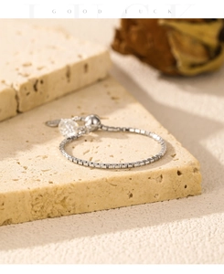 Detail of adjustable silver chain bracelet with slider clasp and lucky charm pendant