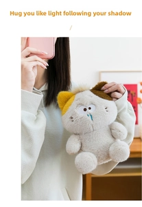 Close-up of cute plush cat doll with asymmetric ears and blue teardrop details