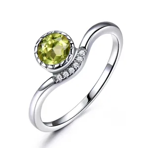 925 silver ring featuring a round peridot stone and five side accent zircons on white