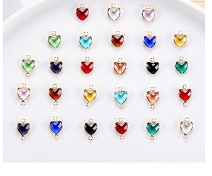 Close-up of colorful heart-shaped crystal charms with gold edges on white plate