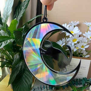 Close-up of crescent moon suncatcher with cat silhouette showing holographic light effect