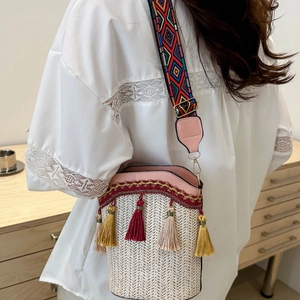 Chic woven bucket bag with bohemian tassels and colorful patterned shoulder strap