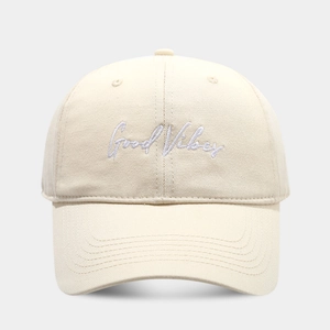Close-up of Good Vibes embroidery on cream cotton twill baseball cap fabric