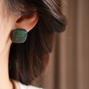 Close-up of green square zircon earrings featuring emerald-like pave setting on model