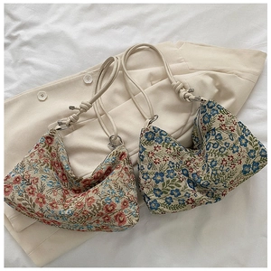 Detail of floral tapestry fabric and knot strap on vintage hobo underarm shoulder bag