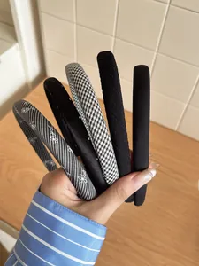 Close-up of five assorted headbands featuring black and white patterns and satin textures