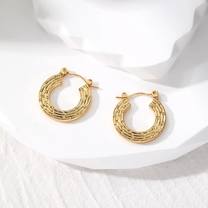 Detailed macro view of gold-plated bamboo-textured hoop earrings with leverback closure