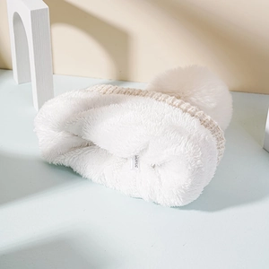 Detail of soft thick white fleece lining and washing label of the knit beanie cap