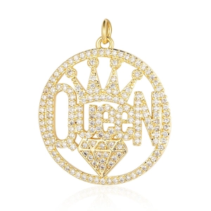 Macro shot of gold circular pendant with Queen lettering, crown design and pavé cubic zirconia