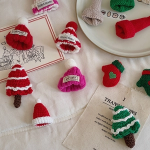 Macro detail of mini knitted Christmas hats and gloves with handmade labels for DIY gifts