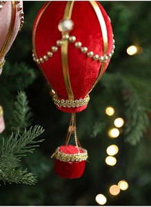 Detailed view of a red velvet hot air balloon Christmas ornament with gold bead accents