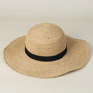 Détail macro du chapeau de soleil en raphia tressé main avec ruban gros-grain noir