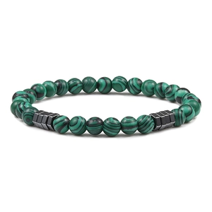 Close-up of 6mm green malachite beads and black geometric metal spacers on a yoga bracelet