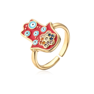 Macro detail of gold-plated Hamsa ring with red enamel, evil eye pattern and colorful stones