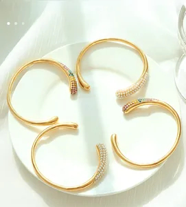 Détail de quatre bracelets plaqués or 18k avec perles blanches et strass colorés