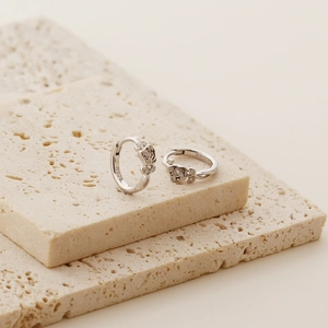 Detail of S925 sterling silver rose earrings with micro-inlaid diamonds on stone