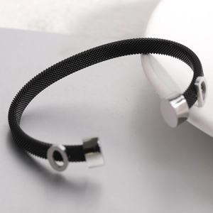 Close-up of black mesh stainless steel cable bracelet with silver circle and D pendant