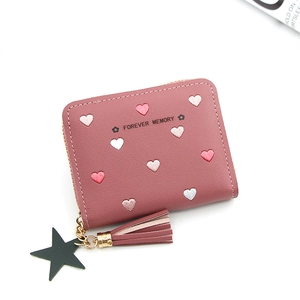 Detail view of heart embroidery on pink mini wallet with star and tassel charm
