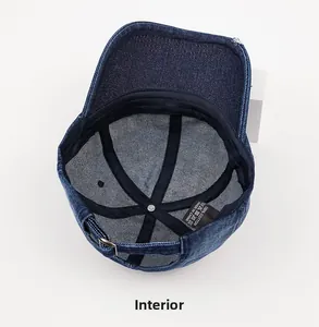 Detail of the inner structure of a blue denim cap featuring 100% cotton wash label