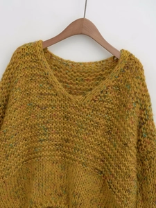 Detail of chunky knit yellow V-neck sweater with colorful rainbow yarn texture