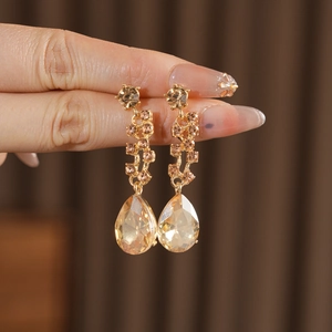 Detailed close-up of champagne teardrop earrings featuring sparkling crystal pavé settings