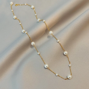 Elegant adjustable pearl necklace with mixed size white pearls on a fine gold chain