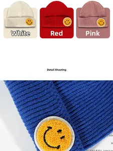Detail of ribbed knit beanie featuring a yellow chenille smiley face patch embroidery