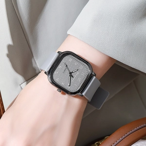 Wrist view of square quartz watch with grey silicone strap and black textured dial