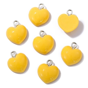 Detail showing multiple yellow resin heart charms with silver metal hanging loops