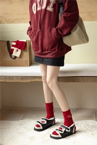 Close-up of festive red cashmere socks with embroidered text and warm fleece sandals