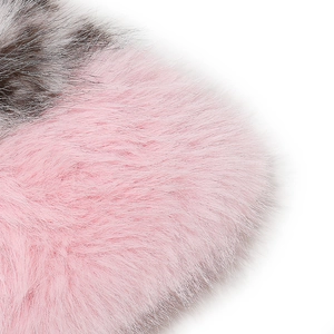 Dettaglio macro della morbida pelliccia sintetica rosa e marrone di un cappello invernale