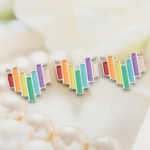 Macro view of three rainbow colorful enamel heart pendants for DIY jewelry making
