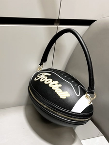 Detailed macro view of black rugby-shaped evening bag featuring gold football embroidery