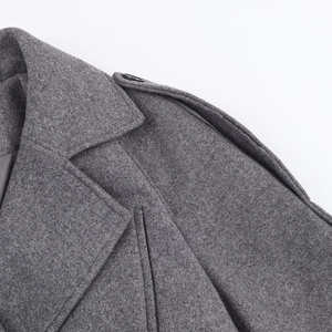 Detailed view of dark grey wool blend coat featuring epaulettes and lapel stitching