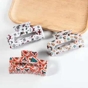 Three large Christmas themed hair claws with Santa, tree, and snowflake patterns
