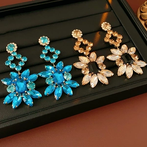 Détail de boucles d'oreilles vintage en forme de fleurs serties de cristaux bleus