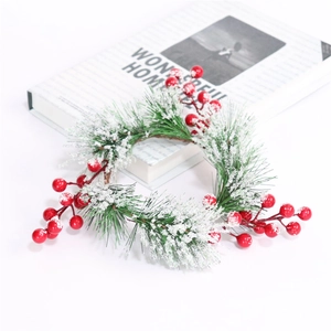 Close-up of artificial cedar pine wreath with red berries and snow on white background