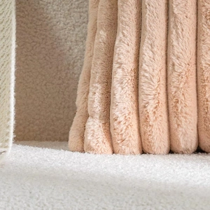 Close-up of pink faux rabbit fur pillow cover with soft striped texture and plush detail