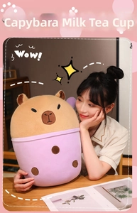 Close-up of a plush capybara milk tea cup toy held by a girl in a cozy home setting